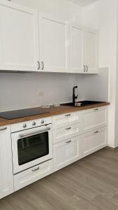 - une cuisine blanche avec des placards blancs et une cuisinière dans l'établissement Casa vacanza Blue Marine, à Sampieri