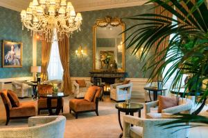 a living room filled with furniture and a chandelier at Grand Hotel Casselbergh in Bruges
