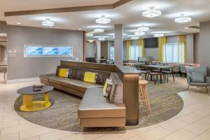 um átrio do hotel com um sofá, mesas e cadeiras em SpringHill Suites Portland Airport em Portland