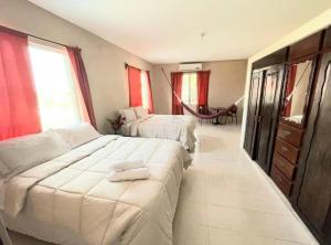 1 dormitorio grande con 2 camas y mesa en Arnold's Guest House en San Ignacio