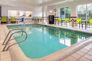 una piscina con sillas y mesas en el vestíbulo del hotel en SpringHill Suites Portland Airport en Portland