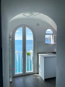 アマルフィにあるAmalfi Saracena Houseの海に面した開放的なドア付きのキッチン