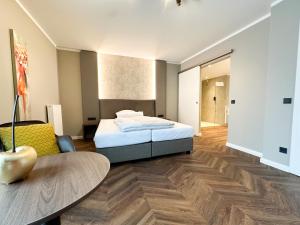 a bedroom with a bed and a table in it at Hotel Restaurant Hackmann-Atter in Osnabrück