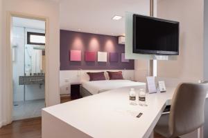 a living room with a white table and a tv at Paulista Suites by Charlie in Sao Paulo