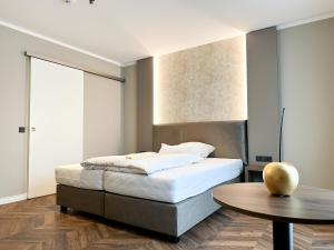 1 dormitorio con cama y mesa de madera en Hotel Restaurant Hackmann-Atter en Osnabrück