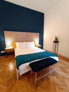 a bedroom with a large bed with a blue wall at PIF Apartments Hirscher in Braşov