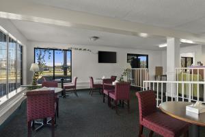una sala de espera con mesas, sillas y TV en Americas Best Value Inn Edenton, en Edenton