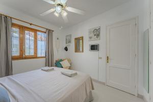 a white bedroom with a bed and a ceiling fan at 2bedroom LosGigantes Amazing View Free Parking Fibre in Acantilado de los Gigantes