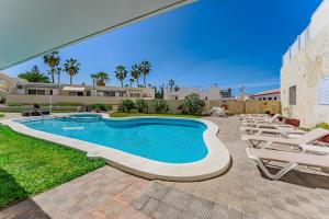 a swimming pool with lounge chairs next to a building at 2bedroom LosGigantes Amazing View Free Parking Fibre in Acantilado de los Gigantes