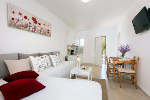 a living room with a white couch and a table at NiSea Apartments in Ipsos