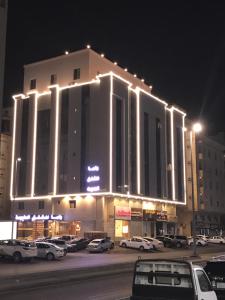 a large building with lights on top of it at night at راما للاجنحة الفندقية in Jeddah
