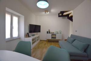 a living room with a blue couch and a tv at A Supressa du Capua in Sestri Levante