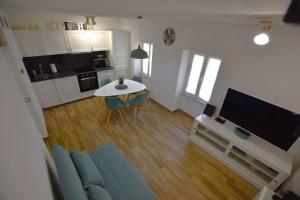 a living room with a couch and a table with a tv at A Supressa du Capua in Sestri Levante