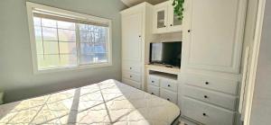 a white room with a tv and a bed at Down the Shore Campground in Ocean View