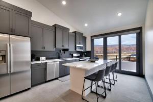 a kitchen with stainless steel appliances and a large window at Vizcaya #6 - Moab's Newest Luxury Rental in Moab