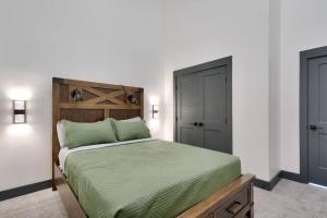 a bedroom with a bed with a green comforter at Vizcaya #6 - Moab's Newest Luxury Rental in Moab
