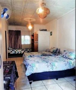 1 Schlafzimmer mit 2 Betten und einem Kronleuchter in der Unterkunft Amazing Grace KZN in Umzinto