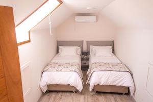 two beds in a small room with white walls at Park Güell House Hotel in Talca