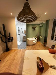 a room with a bathroom with a tub and a cactus at Suite avec Jacuzzi, 15 min de Disneyland Paris - Le Nid d'Eliyah in Nanteuil-lès-Meaux