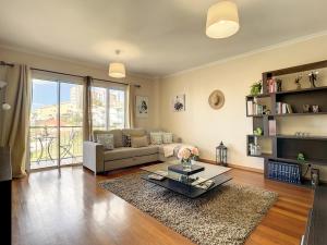 a living room with a couch and a table at Charming Garajau by AH in Caniço