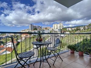 a balcony with two chairs and a table on a balcony at Charming Garajau by AH in Caniço