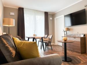 a living room with a couch and a table at Hotel Restaurant Hackmann-Atter in Osnabrück