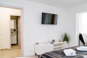 um quarto com uma cama e uma televisão na parede em Studio Lounge em Craiova