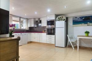 a kitchen with white cabinets and a white refrigerator at Villa del Mar in Puebla de Farnals +44 photos