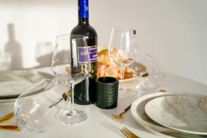 uma mesa com uma garrafa de vinho e dois copos de vinho em Studio Lounge em Craiova