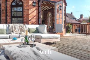 a patio with a couch and a table on a deck at NEW - Country House, Staffordshire in Abbots Bromley