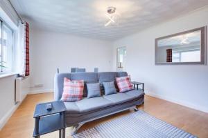 a living room with a blue couch and a window at Lovely 2 Bed Apartment near the Sea in Lancing