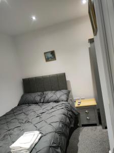 a bedroom with a bed and a nightstand next to it at Spacious Double Bedroom in Liverpool