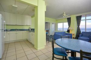a kitchen and dining room with a table and chairs at Palmetto Beachfront Hotel, a By The Sea Resort in Panama City Beach