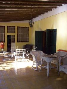 a patio with white chairs and tables and a table at Casa de Campo histórica el ñango in San Martín