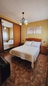 1 dormitorio con 1 cama grande y espejo en la casa del abuelo, en Sebúlcor