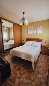 une chambre avec un grand lit et un miroir dans l'établissement la casa del abuelo, à Sebúlcor