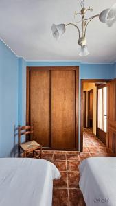 1 Schlafzimmer mit 2 Betten und einer Holztür in der Unterkunft la casa del abuelo in Sebúlcor
