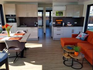 cocina y sala de estar con sofá naranja en Hausboot Marama - LP10 en Peenemünde