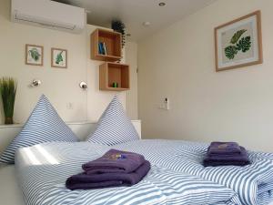 a bed with two purple towels on top of it at Hausboot Marama - LP10 in Peenemünde