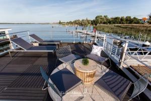 a deck of a boat with chairs and a table at Hausboot KranichNest in Ribnitz-Damgarten