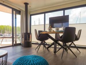 a dining room with a table and chairs and a large window at Hausboot Krosse Krabbe - LP6 in Peenemünde