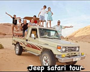 a group of people sitting on the back of a pickup truck at Adel rum camp bubbles in Wadi Rum