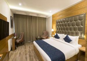 a hotel room with a large bed and a desk at Hotel Seven Inn (R S Gorup Near Delhi Airport) in New Delhi