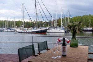 a wooden table with two glasses and a bottle of wine at Hausboot LP1 in Peenemünde