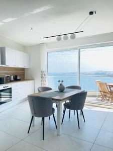a kitchen and dining room with a table and chairs at Blu Mar Sea View Apartments in St. Paul's Bay