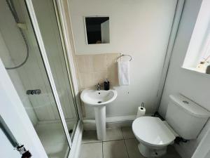 uma casa de banho branca com um WC e um lavatório em Spacious 5-bed house in Coventry by Seeka Stay, Ideal for business, Sleeps 7! em Exhall