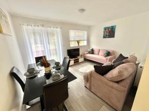 a living room with a couch and a table at Spacious 5 Bed House in Exhall