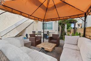 a patio with two couches and an umbrella at Grand Desire - Vibrant - Luxury - Beachside treat in San Diego