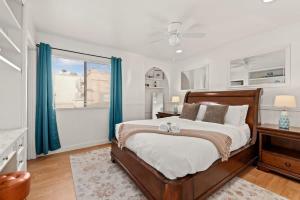 a bedroom with a large bed with blue curtains at Grand Desire - Vibrant - Luxury - Beachside treat in San Diego