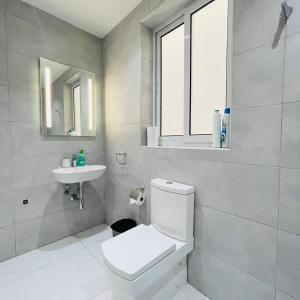 La salle de bains blanche est pourvue de toilettes et d'un lavabo. dans l'établissement Blu Mar Sea View Apartments, à San Pawl il-Baħar